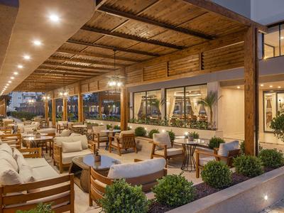 Terraza acogedora de hotel con muebles de madera y luz cálida al atardecer.