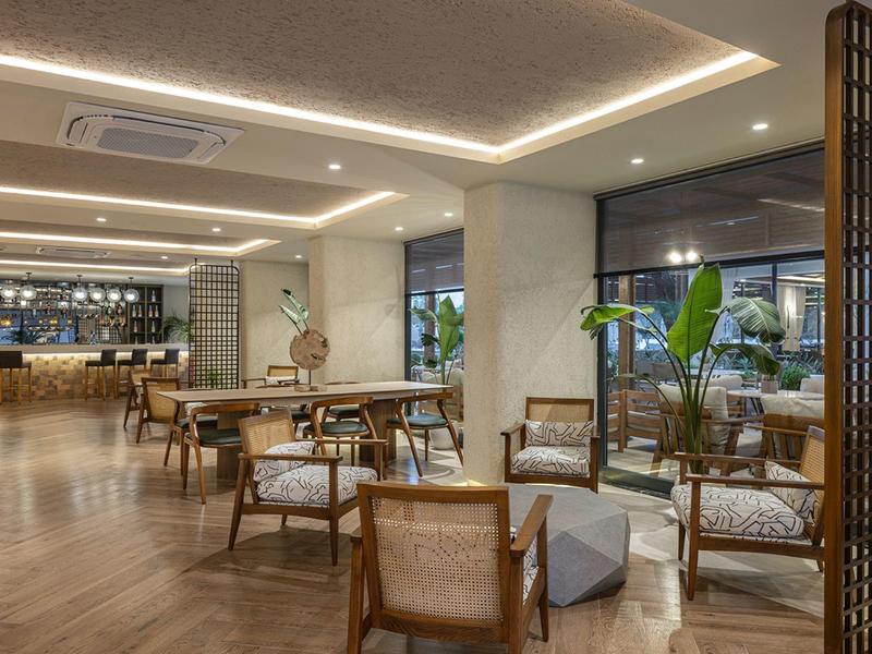 Área de lounge de hotel de diseño moderno con muebles de madera e iluminación indirecta