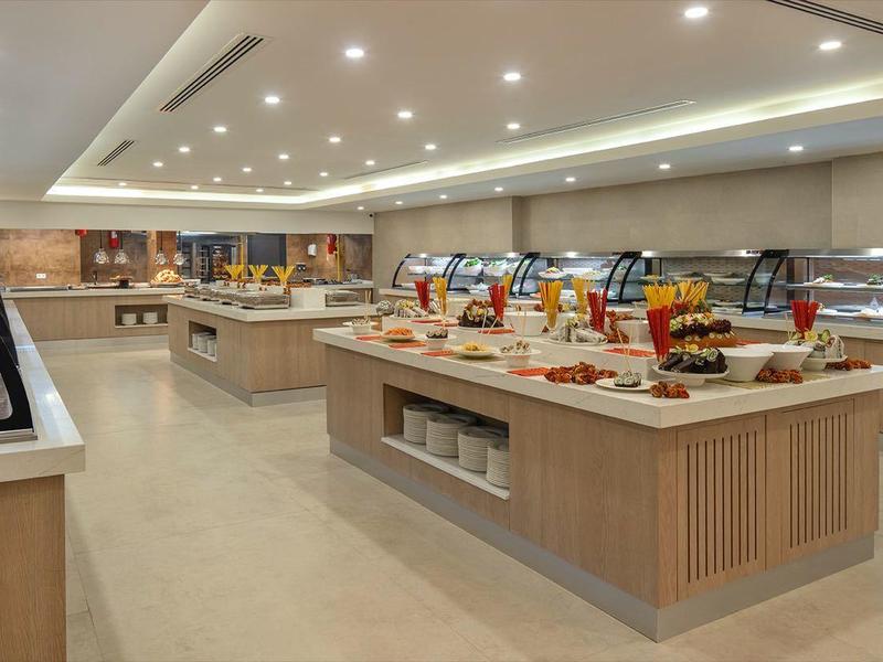 Buffet de desayuno moderno y luminoso con variedad de alimentos y bebidas en un hotel.