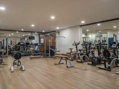 Grande palestra con varie attrezzature per l'allenamento e pavimento in legno.