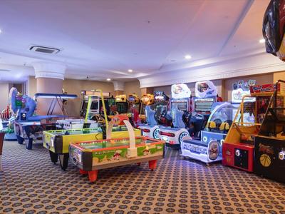 Interior of an arcade with various game machines and a nostalgic carpeted floor.