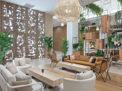 Moderna hall d'hotel con divani comodi, tavoli in legno e piante verdi