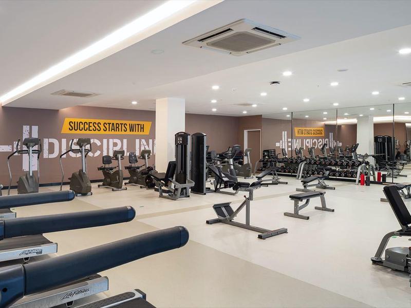 Palestra moderna con tapis roulant, macchine per la forza e pareti specchiate in un hotel.