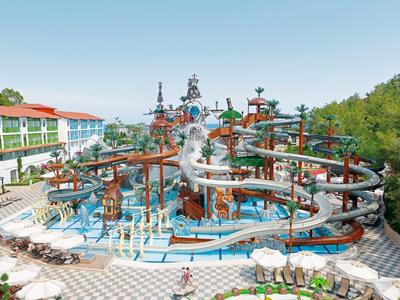 Grand parc aquatique avec toboggans et plusieurs niveaux à côté d'un hôtel