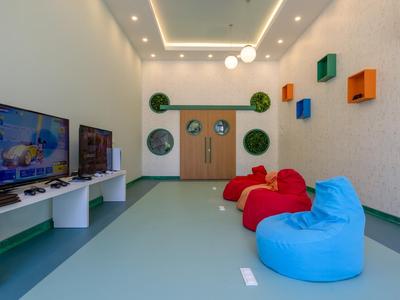 Modern lounge area with colorful bean bags and gaming console in a hotel.