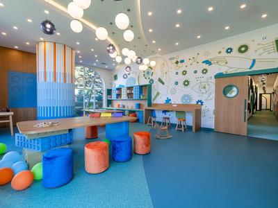 Colorful lounge with stools and tables in a modern hotel interior.