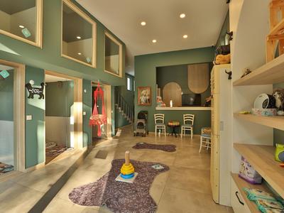 Modernly designed hotel play area with colorful rug and shelves.