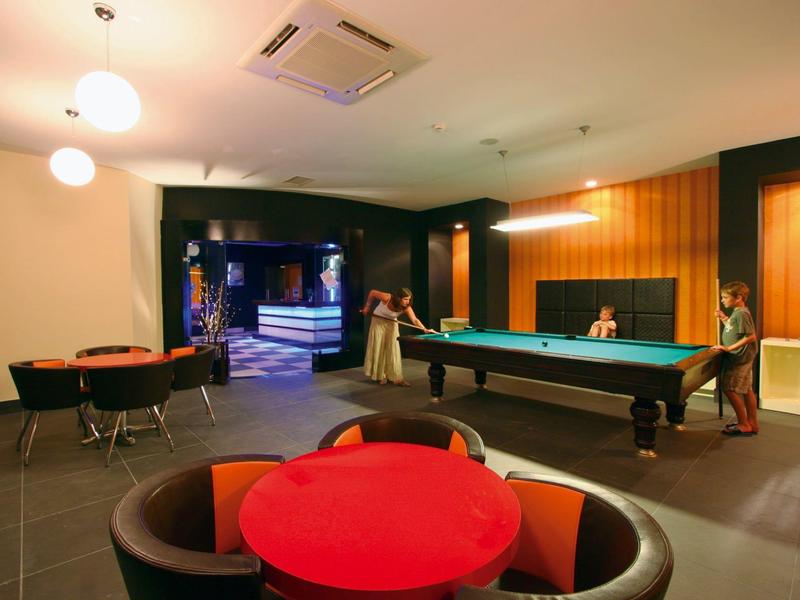 Area lounge moderna con zone salotto e tavolo da biliardo in un hotel.