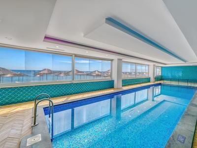 Moderner Innenpool mit großen Fenstern und Blick auf das Meer im Hotel.