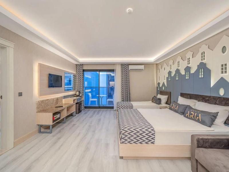 Chambre d'hôtel moderne avec lit double, télévision et fresque murale décorative.