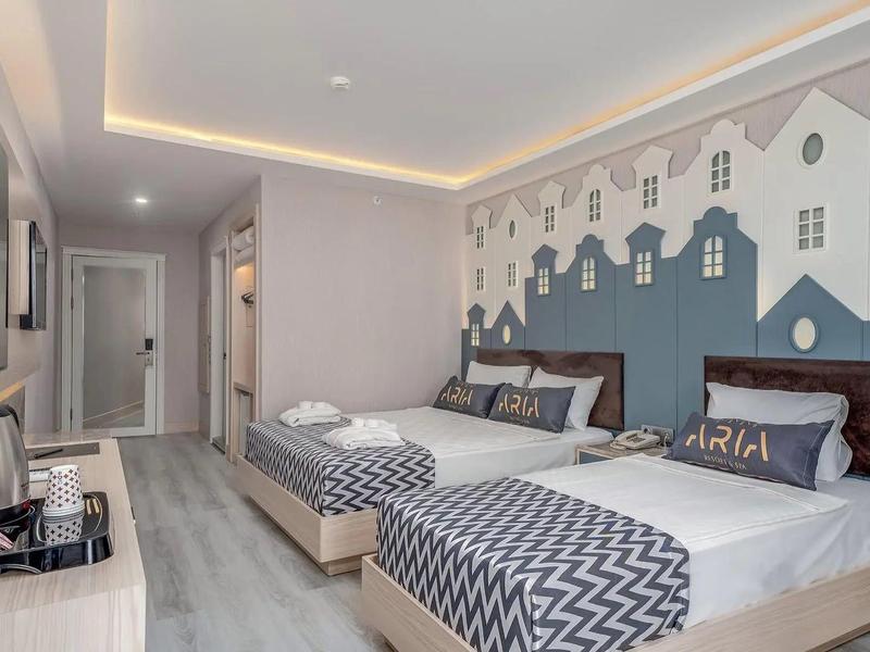 Chambre d'hôtel avec deux lits simples, décoration murale élégante en forme de maisons et design moderne.
