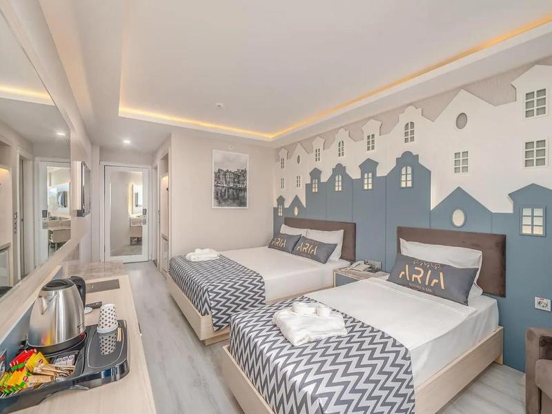 Chambre d'hôtel moderne avec deux lits simples et décoration murale urbaine.