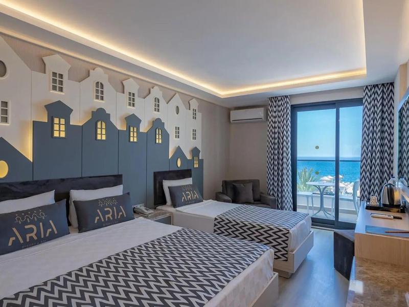 Chambre d'hôtel moderne avec grands lits, vue sur la mer et éclairage élégant