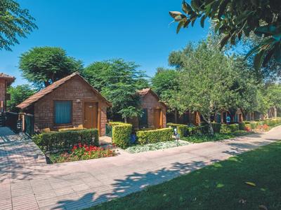 Fila di piccole cabine di legno con giardini in una giornata di sole