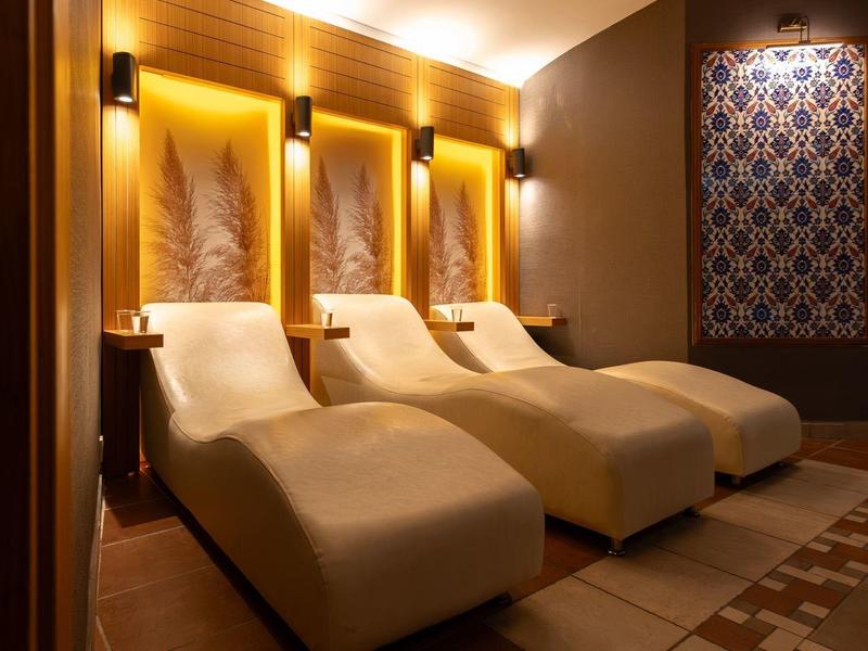 Gezellig spa-gebied met verlichte ligstoelen en warme houten accenten.