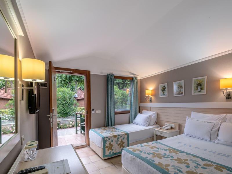 Schoon hotelkamer met twee bedden, balkon en warm licht.