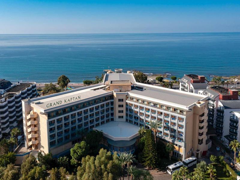 Hotel moderno sul mare con vista panoramica sull'oceano e vegetazione intorno.