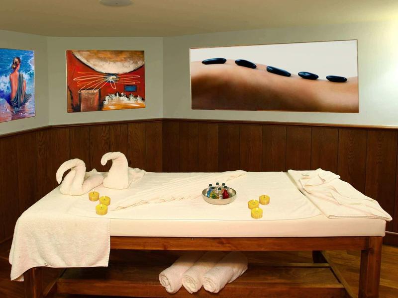 Lettino da massaggio con asciugamani e pietre calde in una stanza spa.