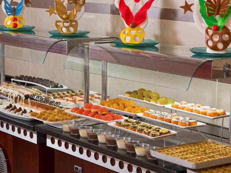 Buffet vario con dolci, frutta e dessert in un ristorante dell'hotel.