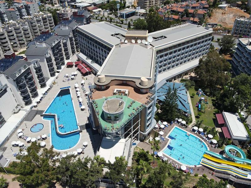 Vista aerea di un hotel moderno con due grandi piscine e scivoli d'acqua.