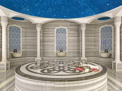 Interno di un bagno turco con marmo bianco e soffitto blu stellato.