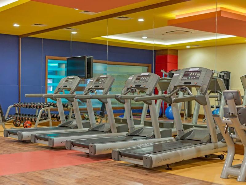 Palestra con diversi tapis roulant moderni allineati.