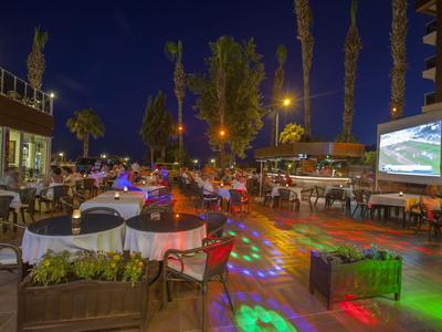 Terrazza dell'hotel di sera con illuminazione decorativa e posti a sedere all'aperto.