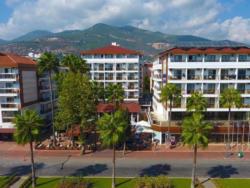 Hotel moderni su più piani con tetti rossi in un paesaggio verde e montuoso.