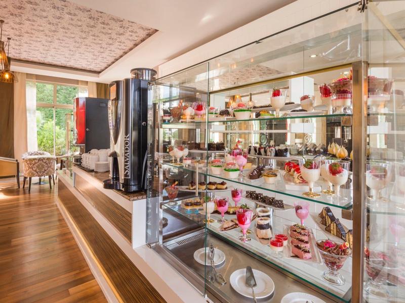 Elegante vetrina buffet con vari dessert in un ristorante moderno con pavimento in legno.