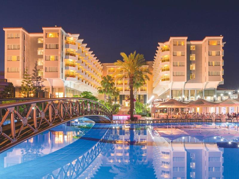 Edificio dell'hotel illuminato con piscina e ponte di notte