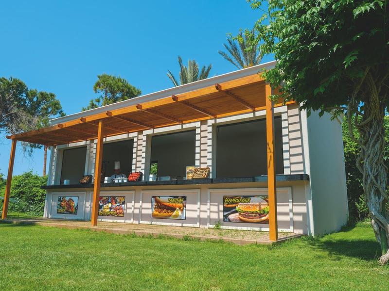 Edificio alberghiero moderno a due piani con ampie finestre e veranda in un ambiente verde.