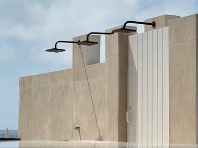 Architettura moderna con lampade esterne e riflesso nell'acqua sotto un cielo sereno.