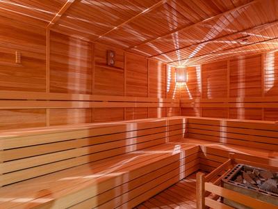 Bright, modern sauna with wooden paneling and indirect lighting for relaxation.