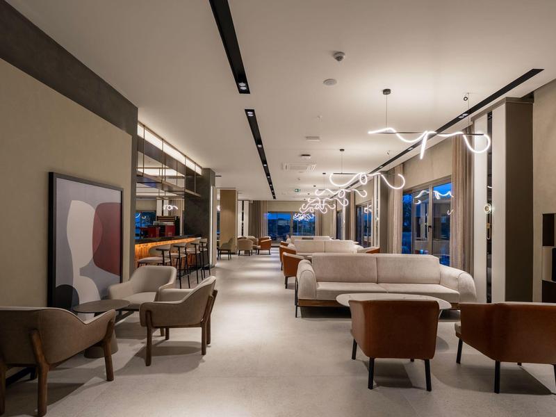 Modern hotel lounge with armchairs, sofas, and stylish lighting.