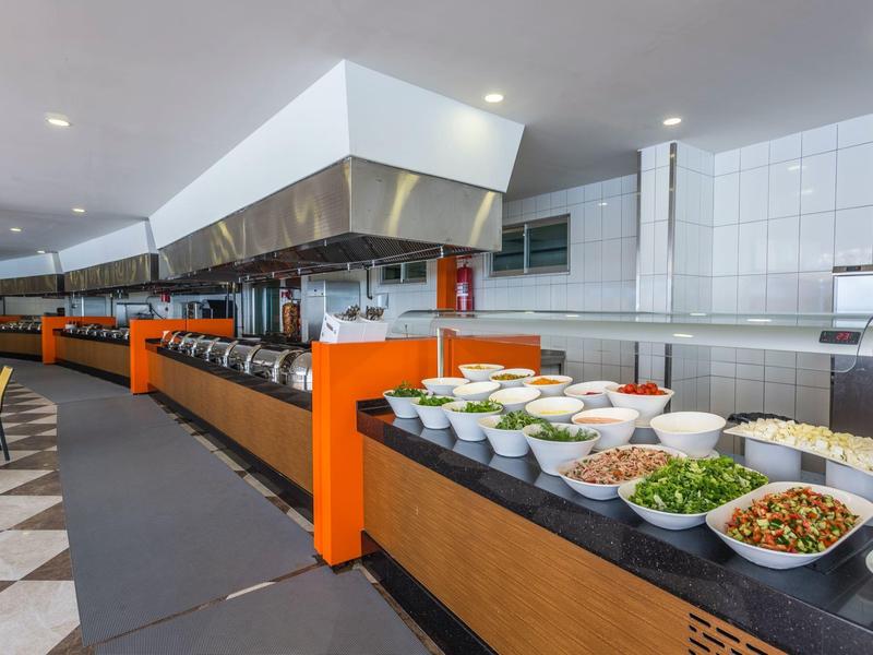 Buffetbereich mit einer langen Verkaufsfläche und Schalen mit verschiedenen Salaten und Zutaten.