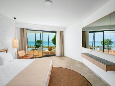 Camera d'hotel moderna con letto grande e vista sulla terrazza e sul mare.