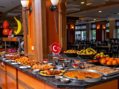 Un buffet avec divers plats et des fruits frais dans un restaurant d'hôtel.