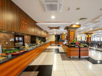 Buffet spacieux dans une salle à manger d'hôtel moderne et lumineuse avec des éléments en bois et carrelage.