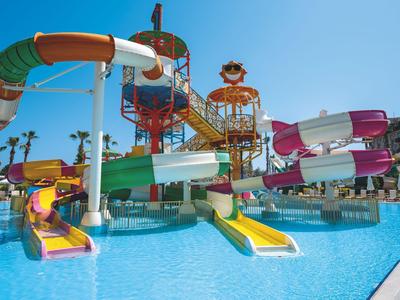 Bunte Wasserrutschen und Pools in einem Wasserpark bei klarem Himmel.