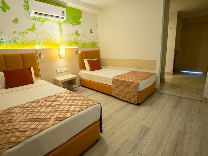 Hotelový pokoj se dvěma jednolůžky, nočním stolkem a moderní výzdobou stěn.