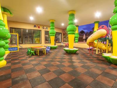 Bunter Indoor-Spielplatz mit Rutschbahn, Kletterelementen und weichem Bodenbelag in Kindergröße.