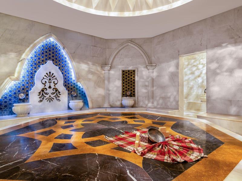 Elegante hammam turco con piastrelle intricate e illuminazione calda.