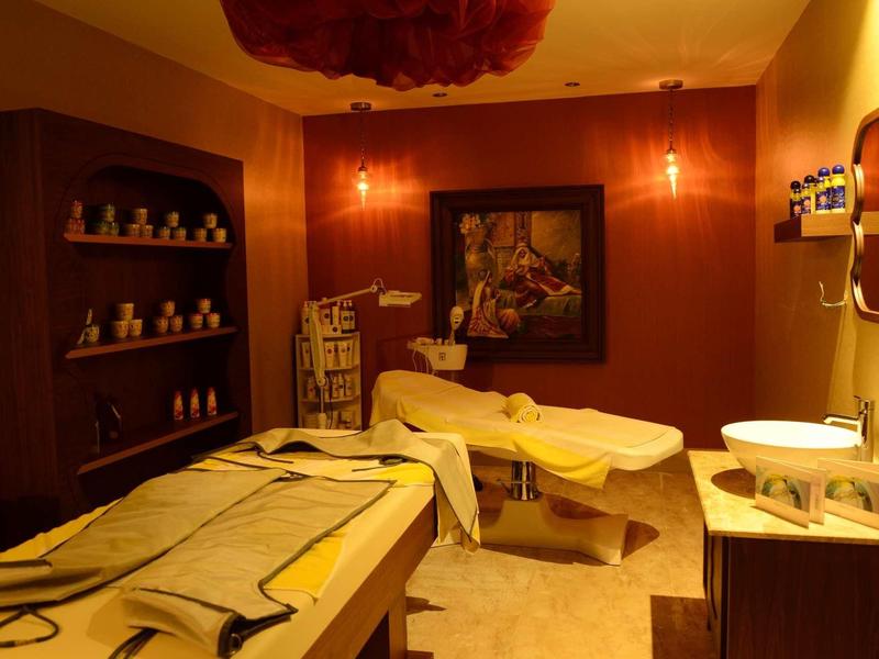 Accogliente sala benessere con lettini da massaggio, illuminazione rilassante e accessori decorativi.