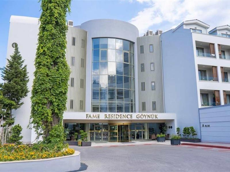 Edificio alberghiero moderno con facciata in vetro e ambiente verde in una giornata di sole