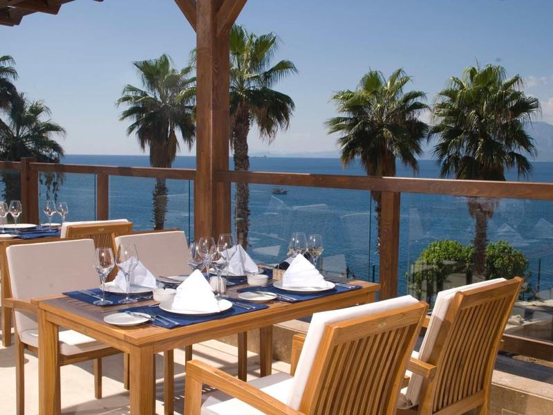 Aantrekkelijk zwembad met helderblauw water en ligstoelen met uitzicht op een meer en bergen.