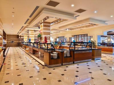 Ristorante buffet moderno e ben illuminato con ampia sala da pranzo e pavimento in marmo.