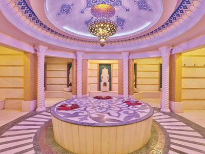 Spazio circolare di lusso con soffitto decorato e piattaforma centrale con petali di rosa.