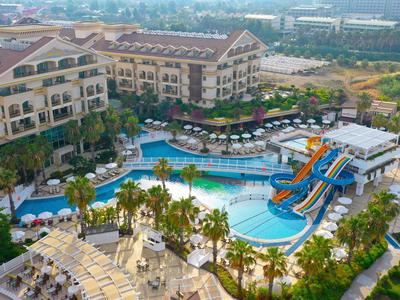 Grande resort alberghiero con piscine multiple, scivoli d'acqua e terrazze soleggiate.