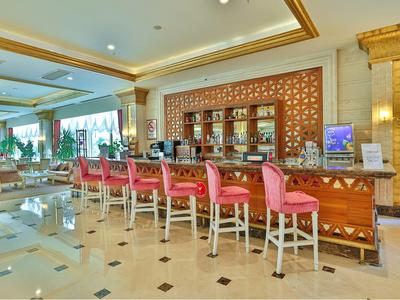 Bar di hotel di lusso con sgabelli rossi e design elegante.