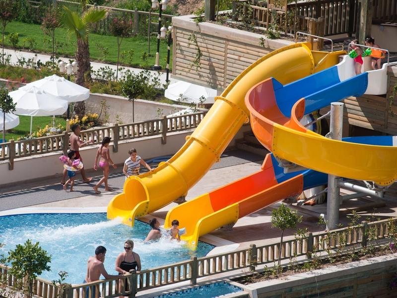 Scivoli d'acqua colorati con persone in una piscina di un hotel.